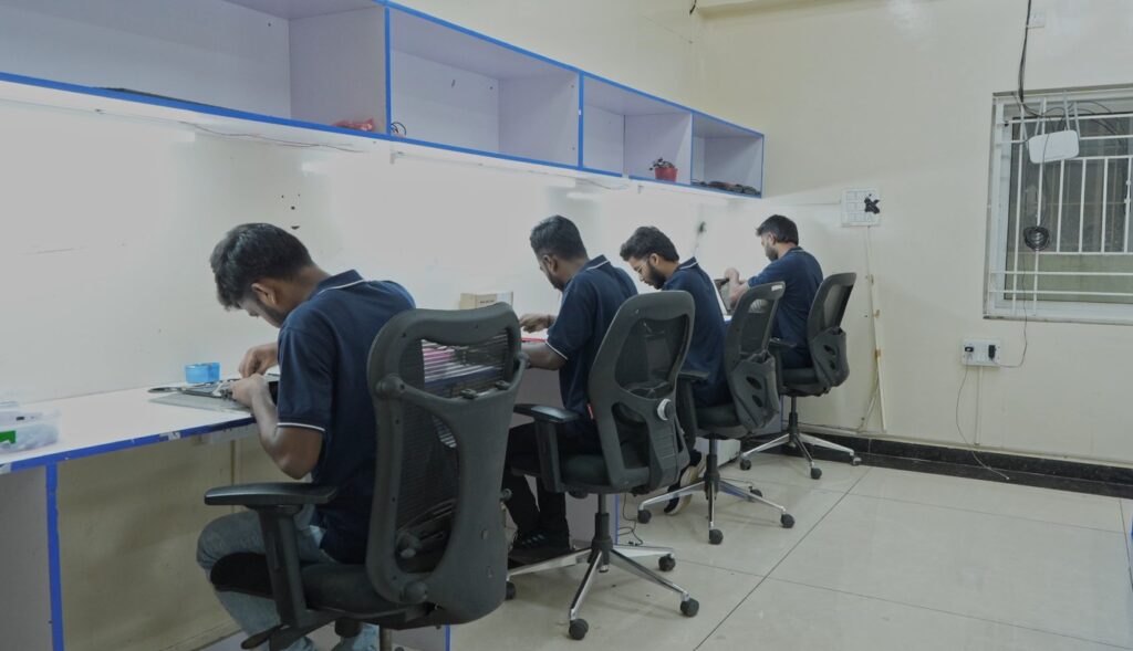 Bethel Computech service engineers working at dedicated repair workstations, performing laptop diagnostics, hardware troubleshooting, component-level repairs, and quality checks in a professional technical support environment.