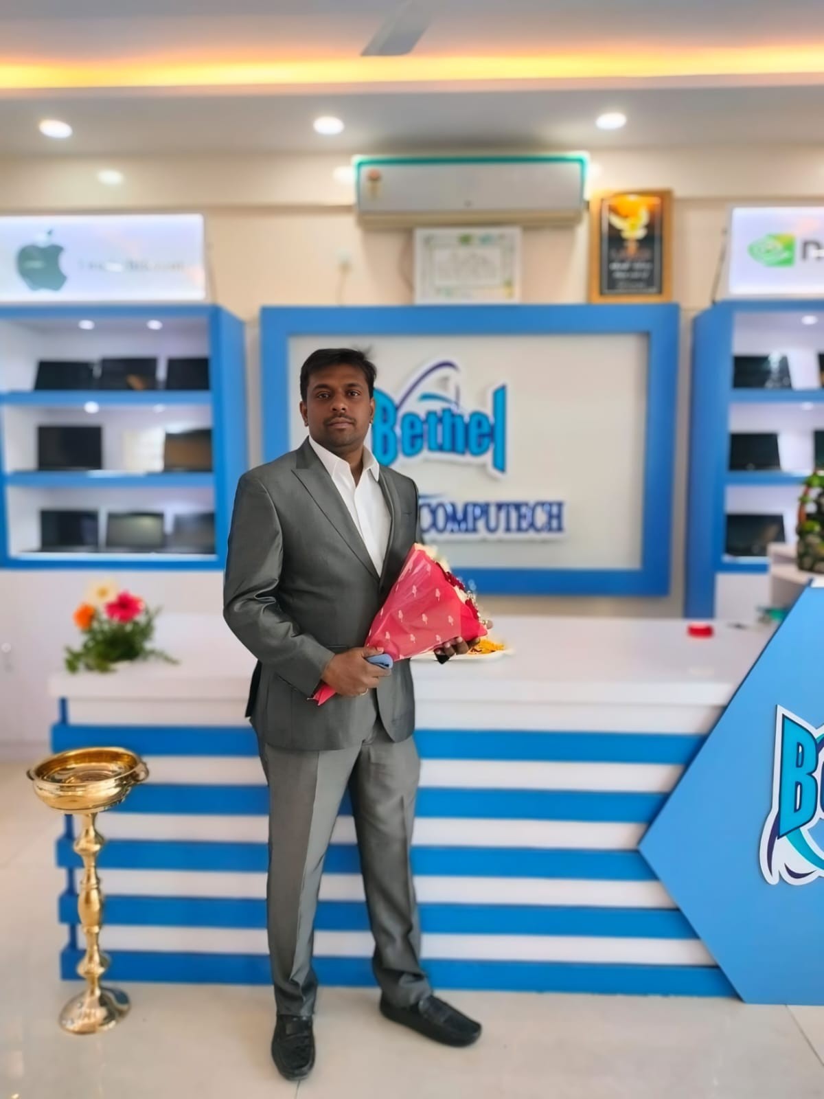 Professional portrait of Bethel Computech team member standing at the reception area of the company showroom.